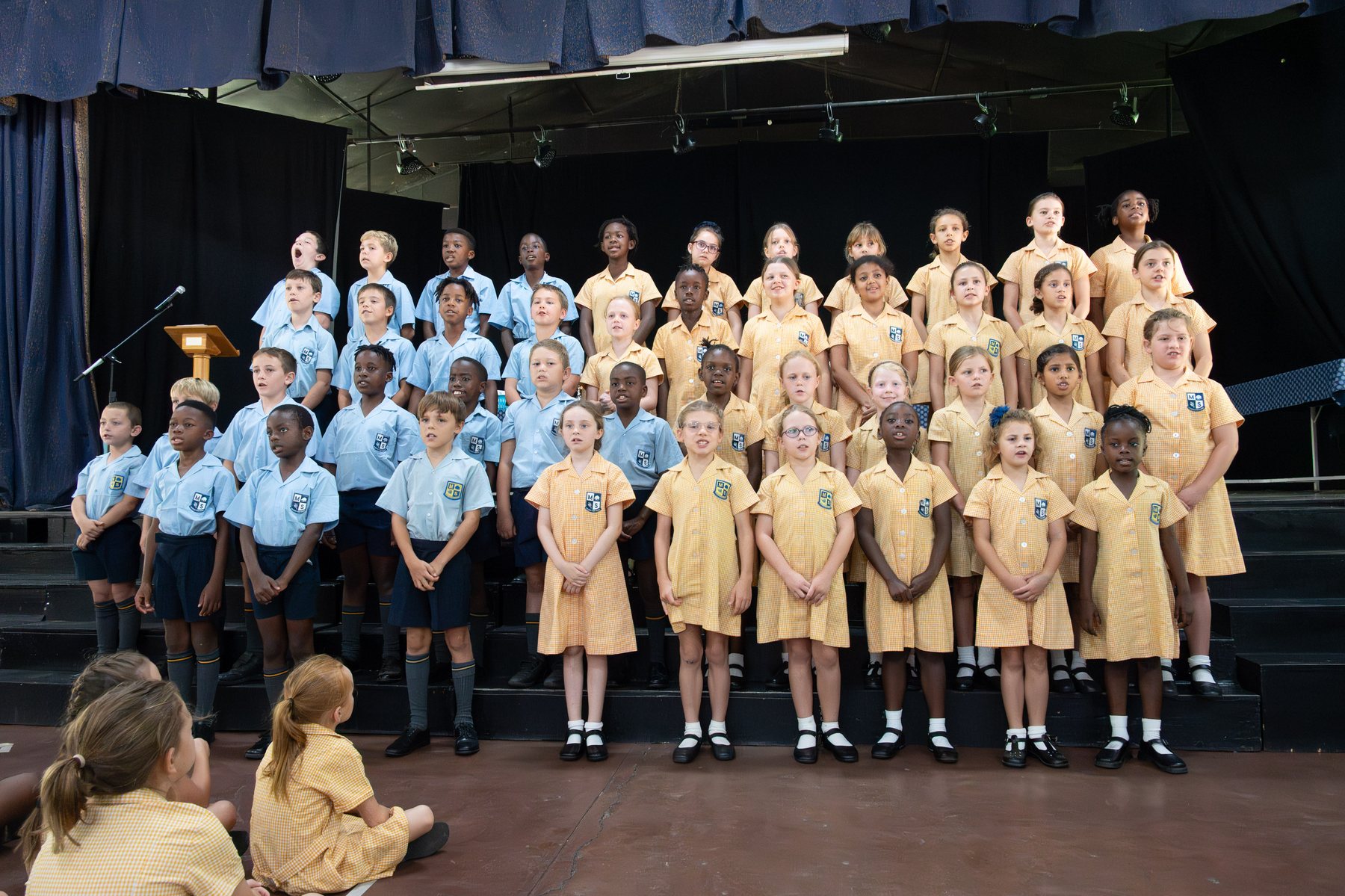 Musikili pupils in uniform singing on stage at prizegiving